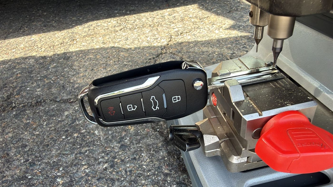 Flip key remote with its blade clamped in a key cutting machine