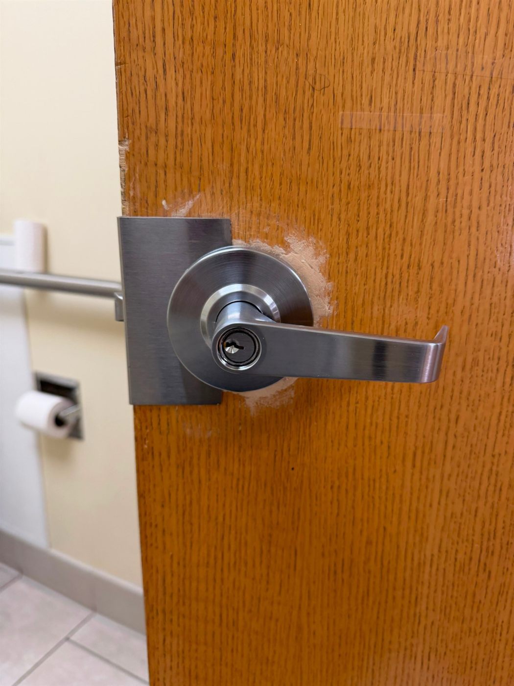 New keyed lever lock installed on a wooden office door