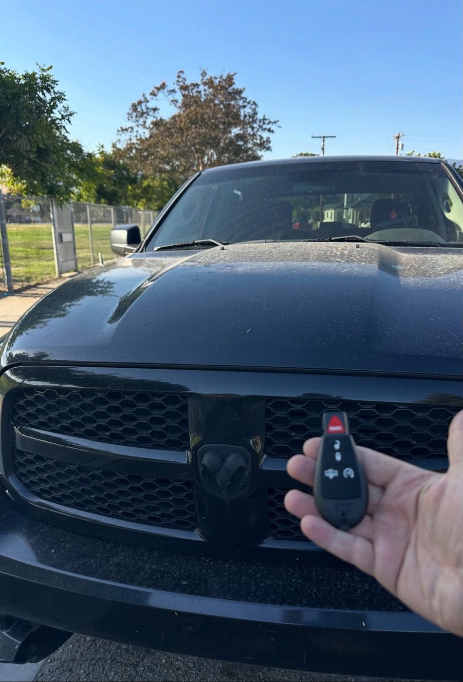 New key fob held in front of a black pickup truck