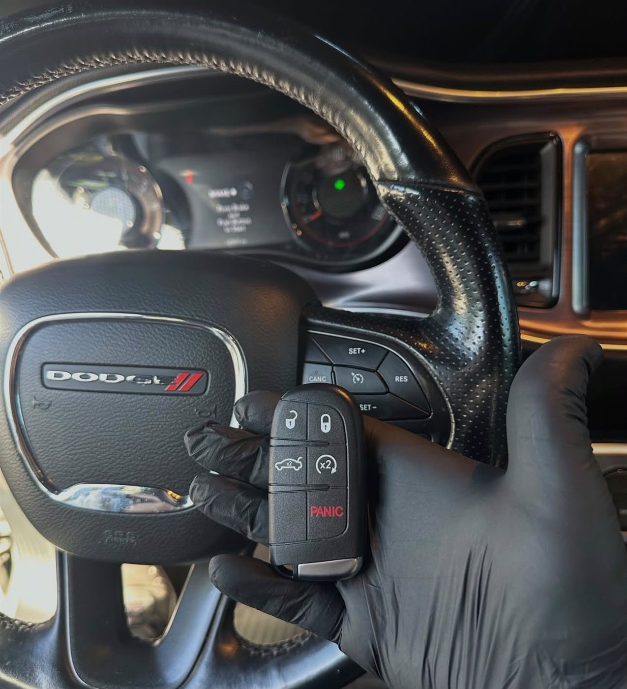 New push-to-start smart key held in front of a steering wheel