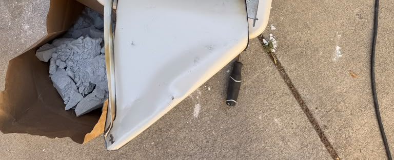Safe door cut and peeled open, with its fire-resistant fill removed into a paper bag