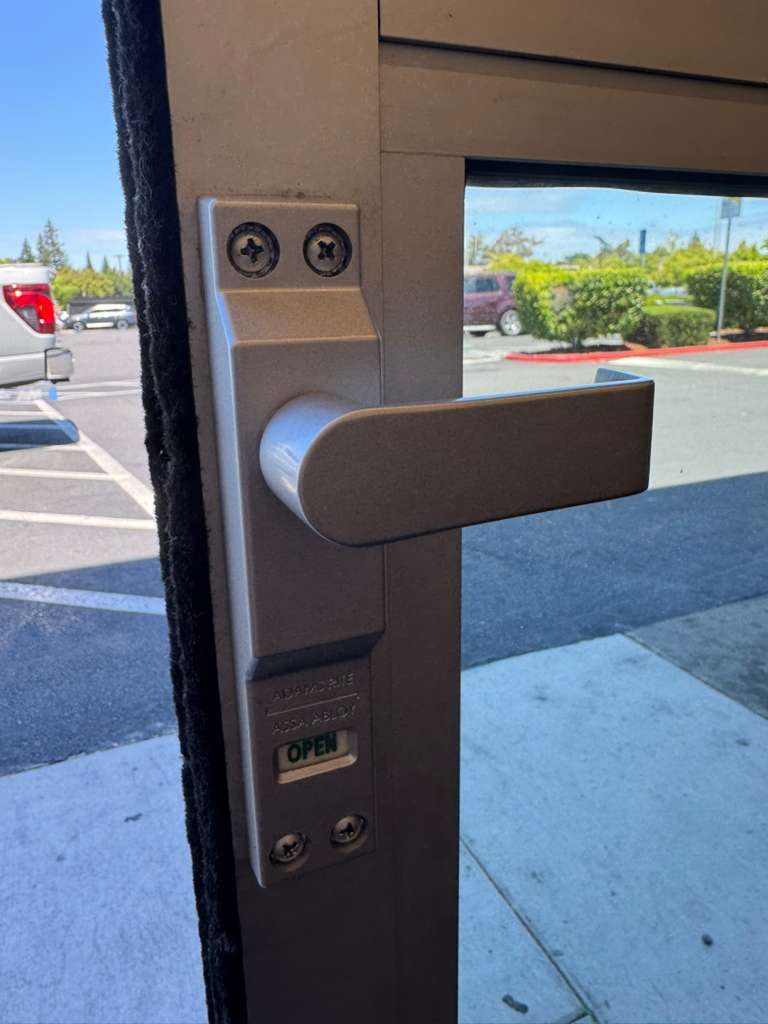 Lever handle and lock with an open indicator on an aluminum storefront door