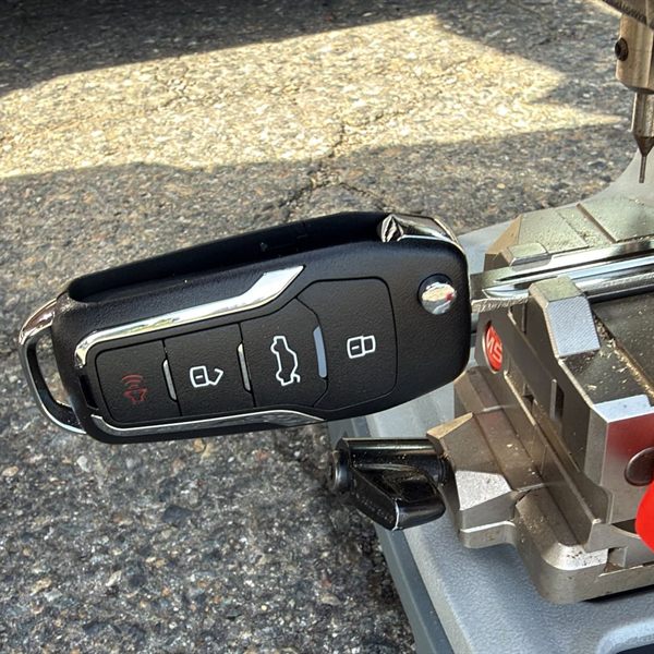 Flip key remote with its blade clamped in a key cutting machine