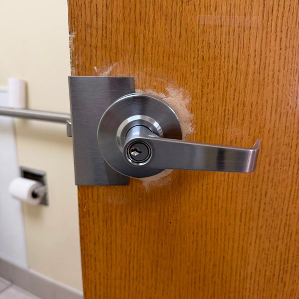 New keyed lever lock installed on a wooden office door