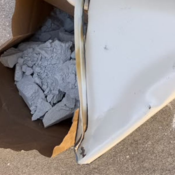 Safe door cut and peeled open, with its fire-resistant fill removed into a paper bag