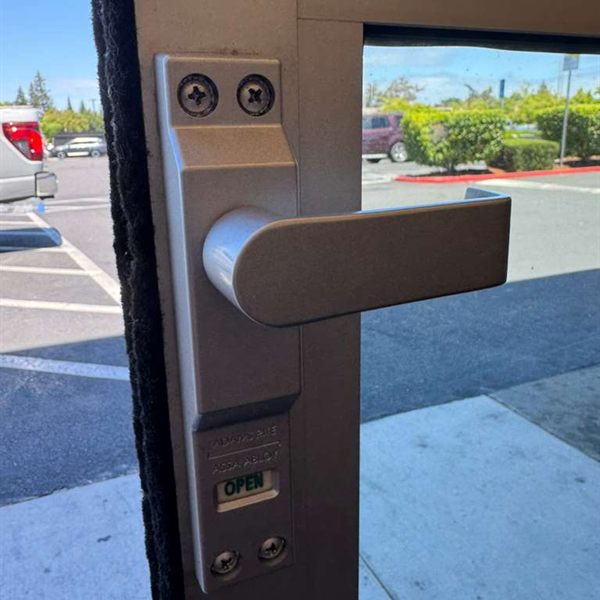 Lever handle and lock with an open indicator on an aluminum storefront door