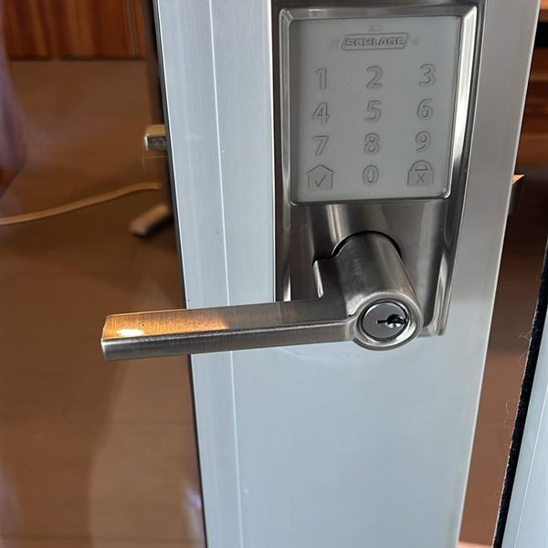 Touchscreen keypad lever lock installed on a glass door frame