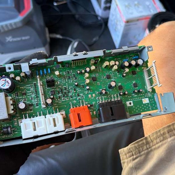 Vehicle electronic control module circuit board removed for key programming