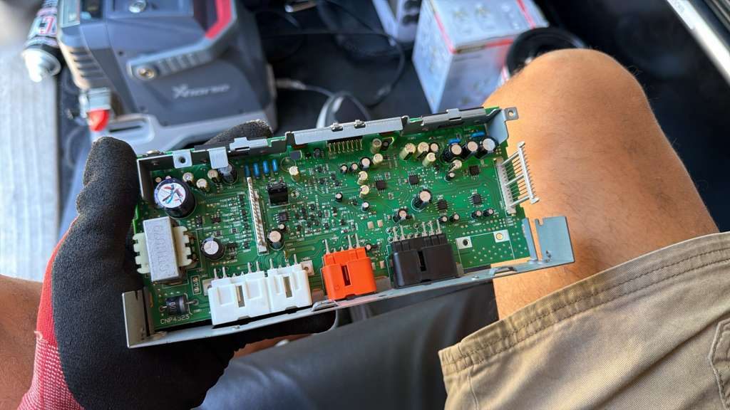 Vehicle electronic control module circuit board removed for key programming